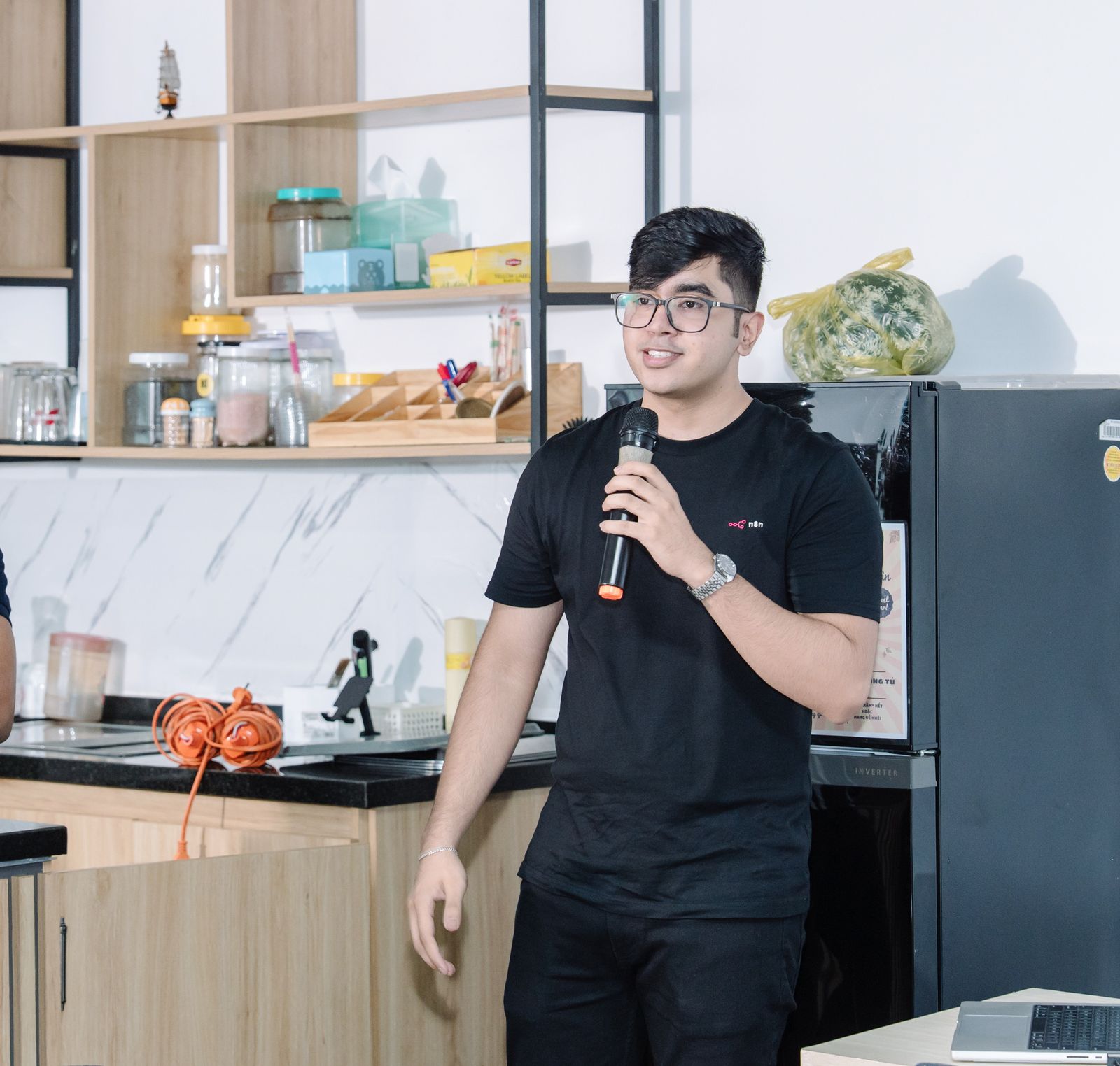 Anshul Namdev speaking on the mic at the n8n Builders Challenge in Ho Chi Minh City
